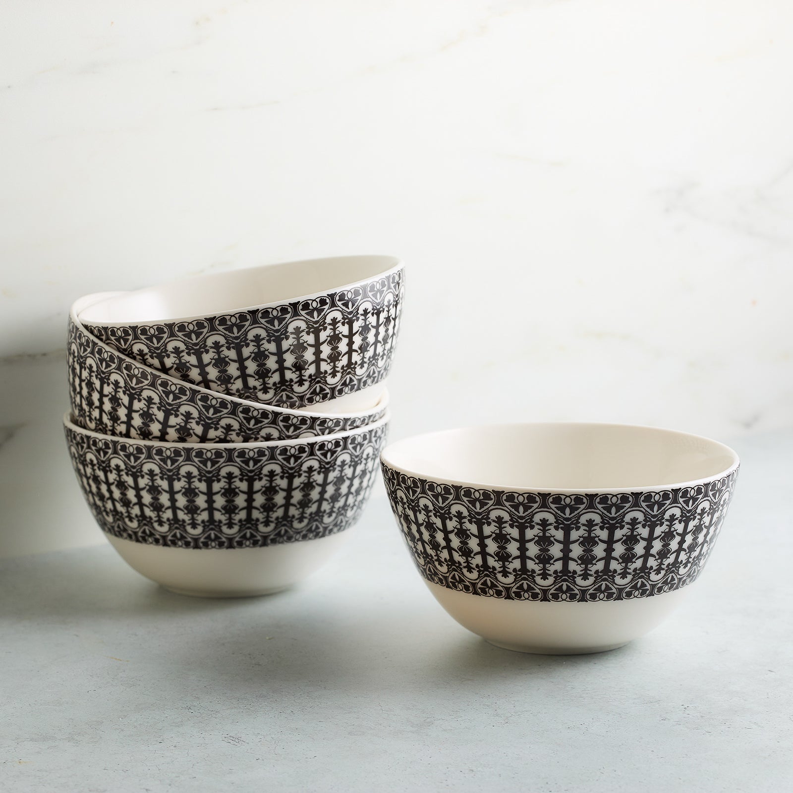 A white ceramic Casablanca Cereal Bowl with intricate black decorative patterns around the exterior, part of the Caskata Artisanal Home dinnerware collection.