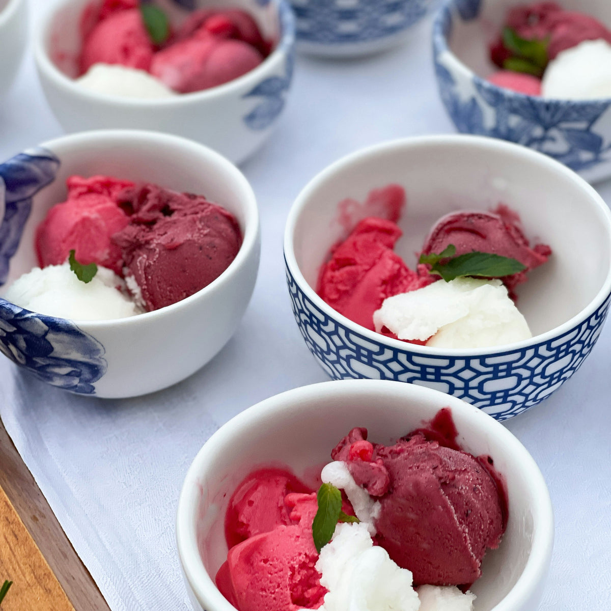 Four Newport Snack Bowls of ice cream topped with berries and mint.