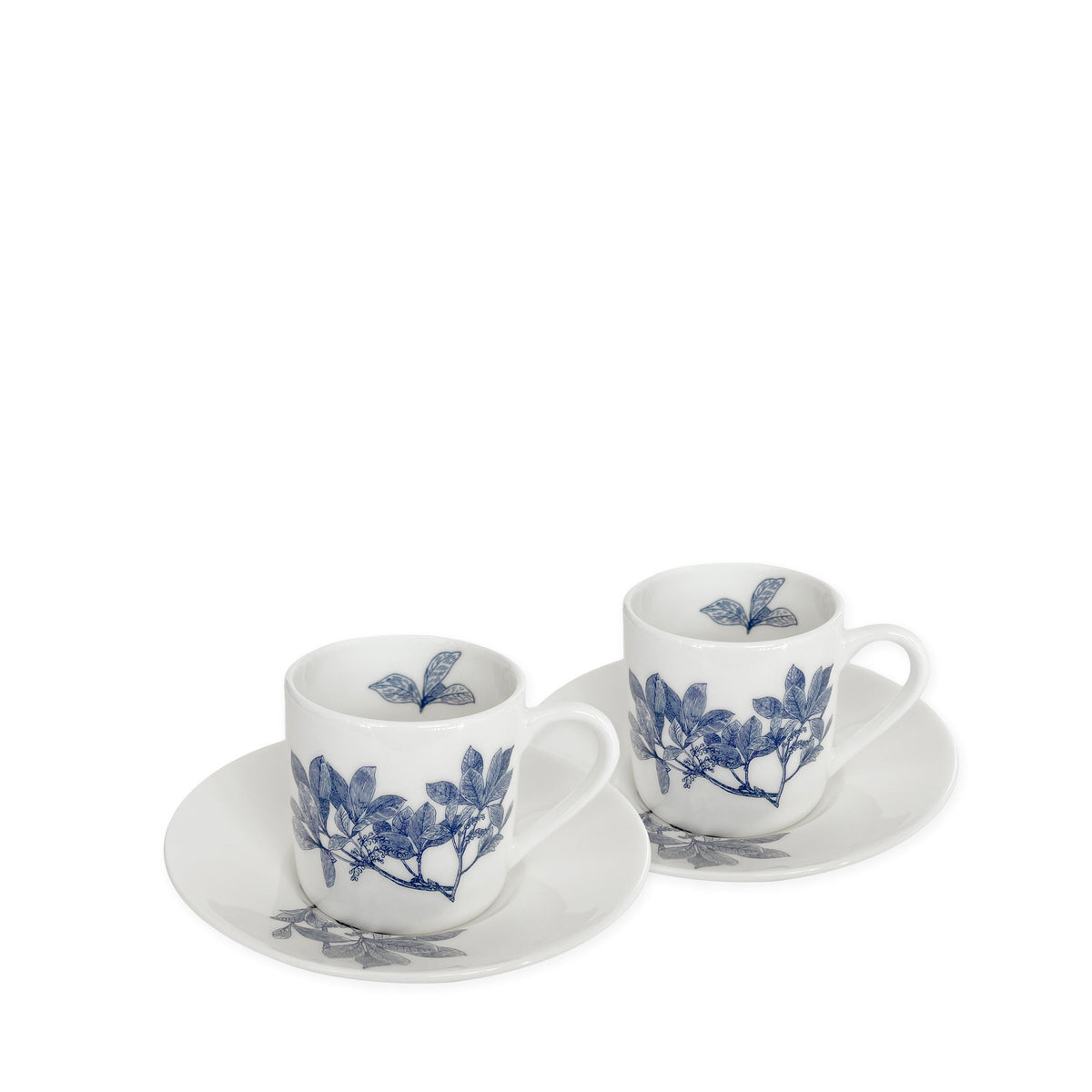 Two white ceramic cups with matching saucers, each adorned with blue floral designs, are perfect additions to any Blue and White Dinnerware collection. The Arbor Espresso Cups &amp; Saucers, Set of 2 by Caskata are microwave-safe pieces that offer both beauty and practicality for everyday use.