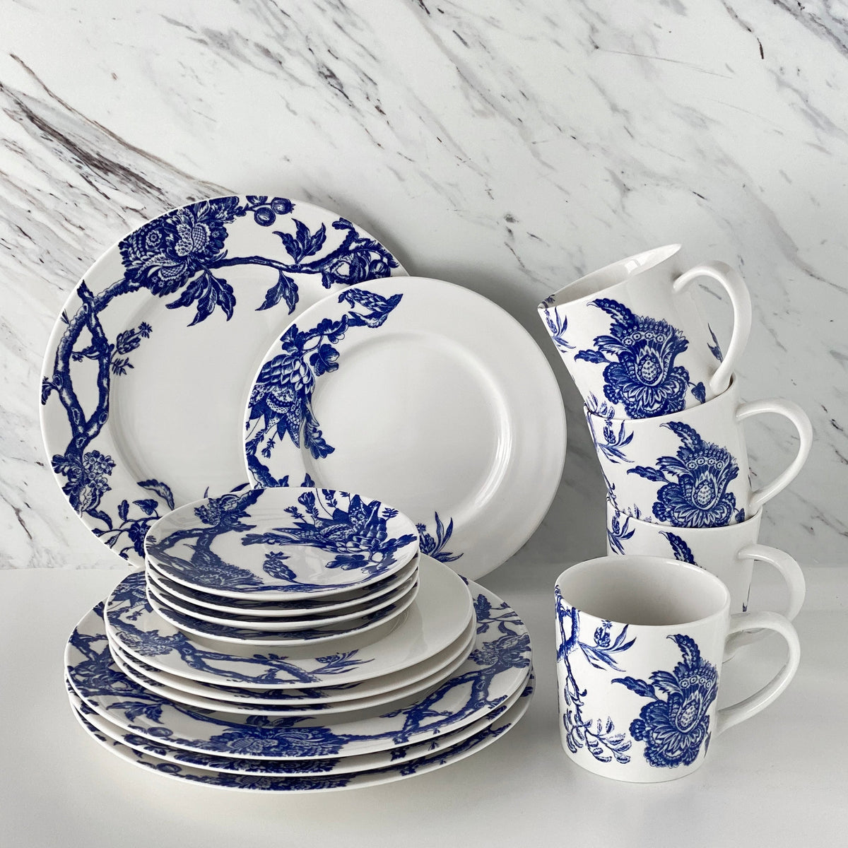 The Arcadia Blue 16 Piece Dinnerware Set by Caskata includes four each dinner, salad and canape plates as well as four wide mouth mugs.