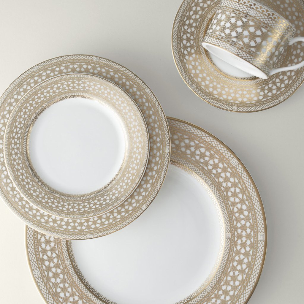 A set of luxurious Hawthorne Gilt Bread &amp; Butter Plates beautifully displayed on a clean white surface. Brand: Caskata Artisanal Home.