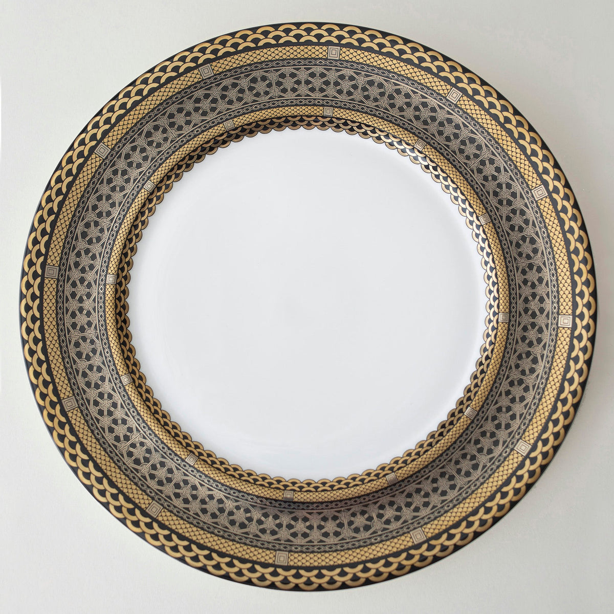 A Hawthorne Onyx Gold &amp; Platinum Charger Plate with a luxurious gold border made by Caskata Artisanal Home.