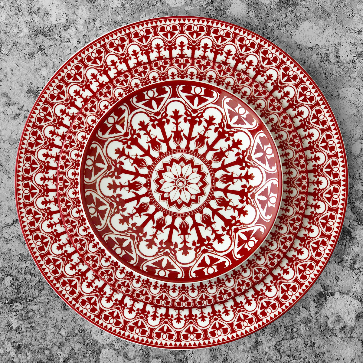 A Casablanca Crimson Salad Plate from Caskata Artisanal Home, with an ornate pattern, made of premium porcelain dinnerware that is dishwasher and microwave safe.