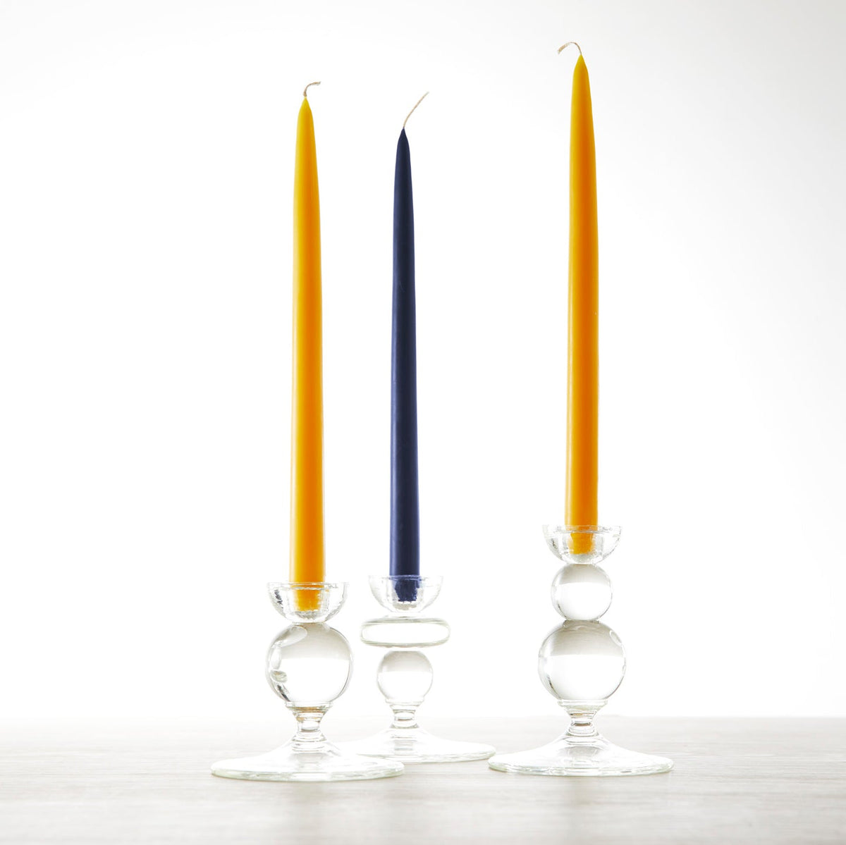 Three **18&quot; Marigold Taper Candles - Set of 2** with yellow and blue candles, by the **Floral Society**.