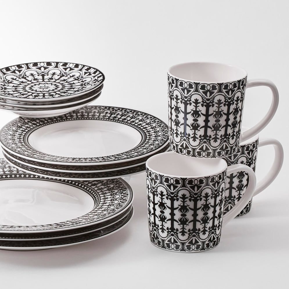 A set of dinner plates in black and white, elegantly arranged on a white surface for a classic Caskata Casablanca Table for 4-inspired table setting.