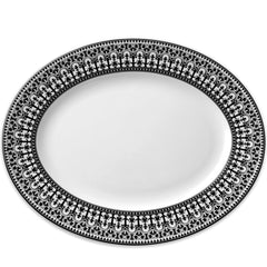 An oval plate with an intricate black and white decorative border, reminiscent of Casablanca dinnerware. The Caskata Artisanal Home Casablanca Oval Rimmed Platter is empty.