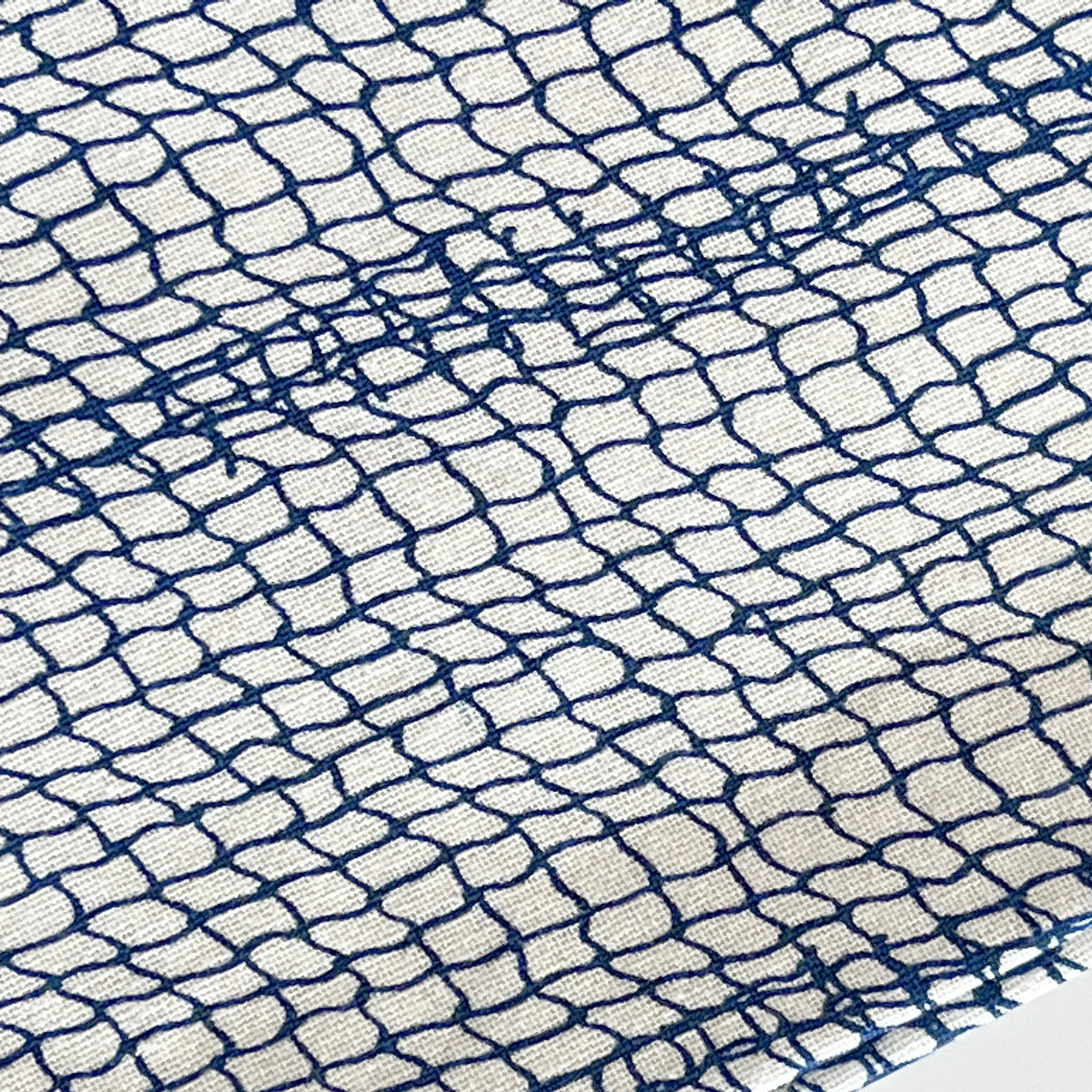 A close up of a Caskata Coastal Blue and White Catch Dinner Napkins Set/4 with a geometric pattern.