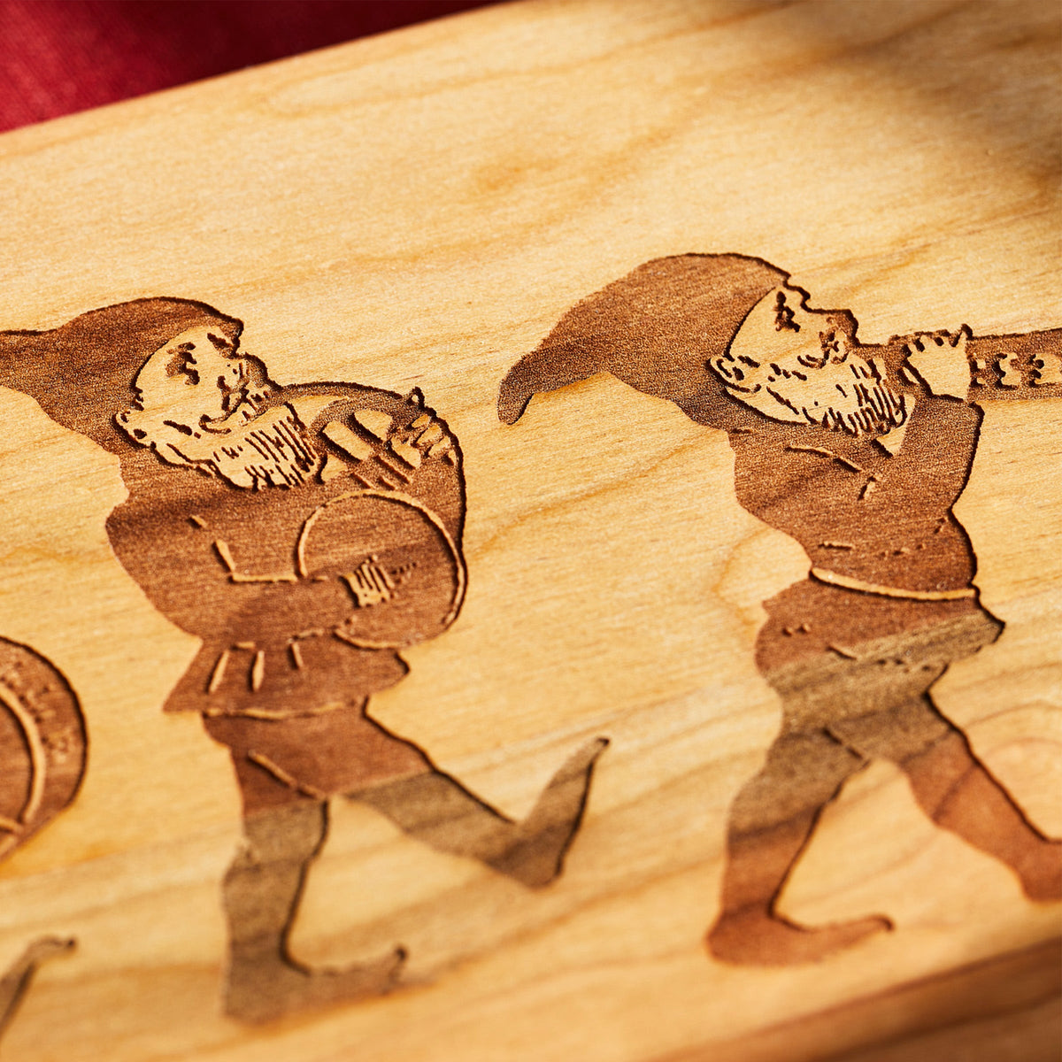 A Caskata Elves Serving Board with three gnomes on it, exuding holiday whimsy.