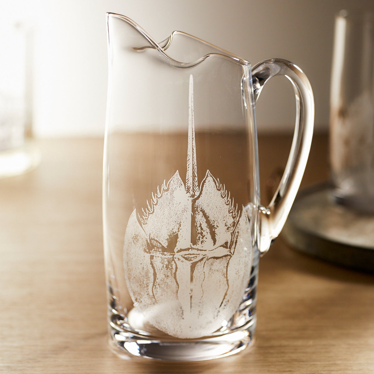 A Horseshoe Crab Small Pitcher by Caskata with an engraved design on it.