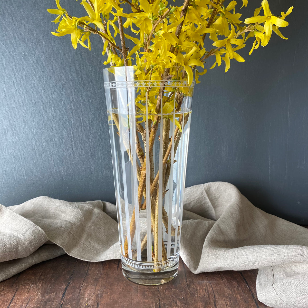 A Marrakech Glass Vase with yellow flowers in graphic patterns by Caskata.