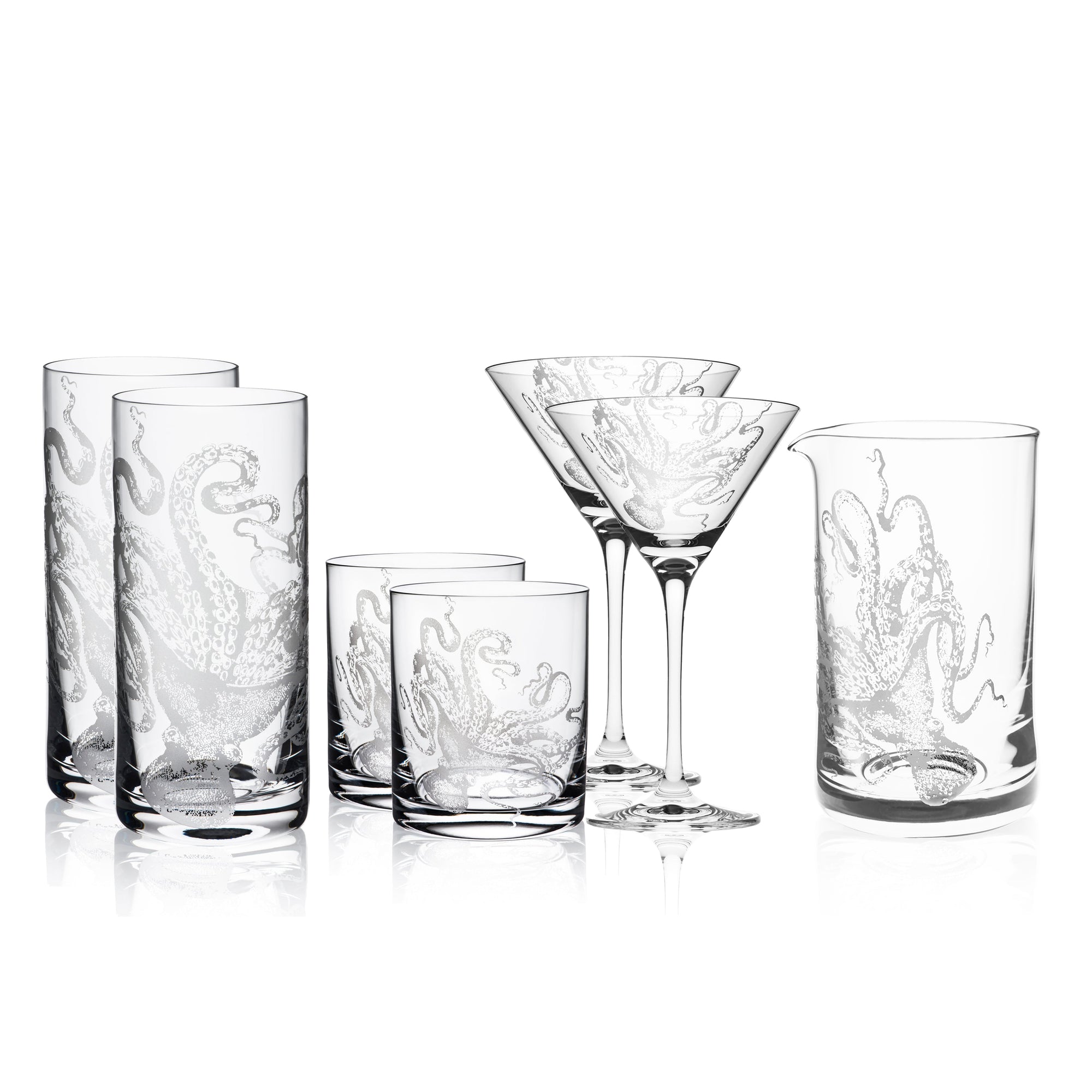 A collection of octopus glassware, including the "I Love Lucy" Cocktail Collection by Caskata Artisanal Home with etched octopus designs, features four highball glasses, two crystal cocktail glasses, and two tumblers, all arranged against a white background.