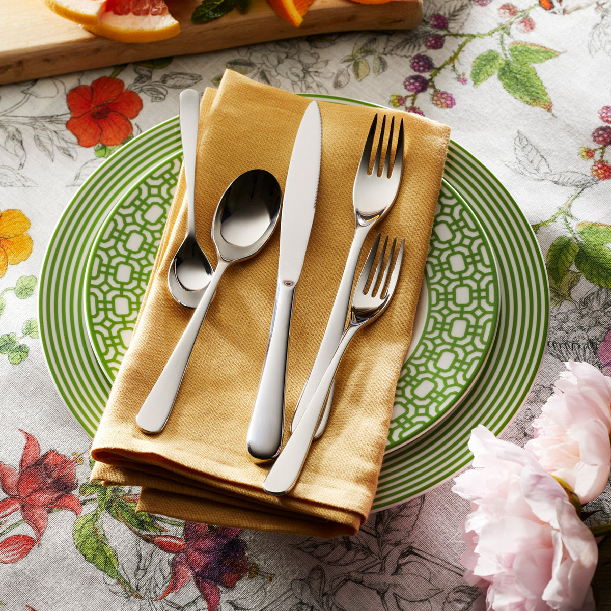 A Degrenne La Mer 5-Piece Flatware Setting, a lightweight plate with contemporary design, featuring silverware.