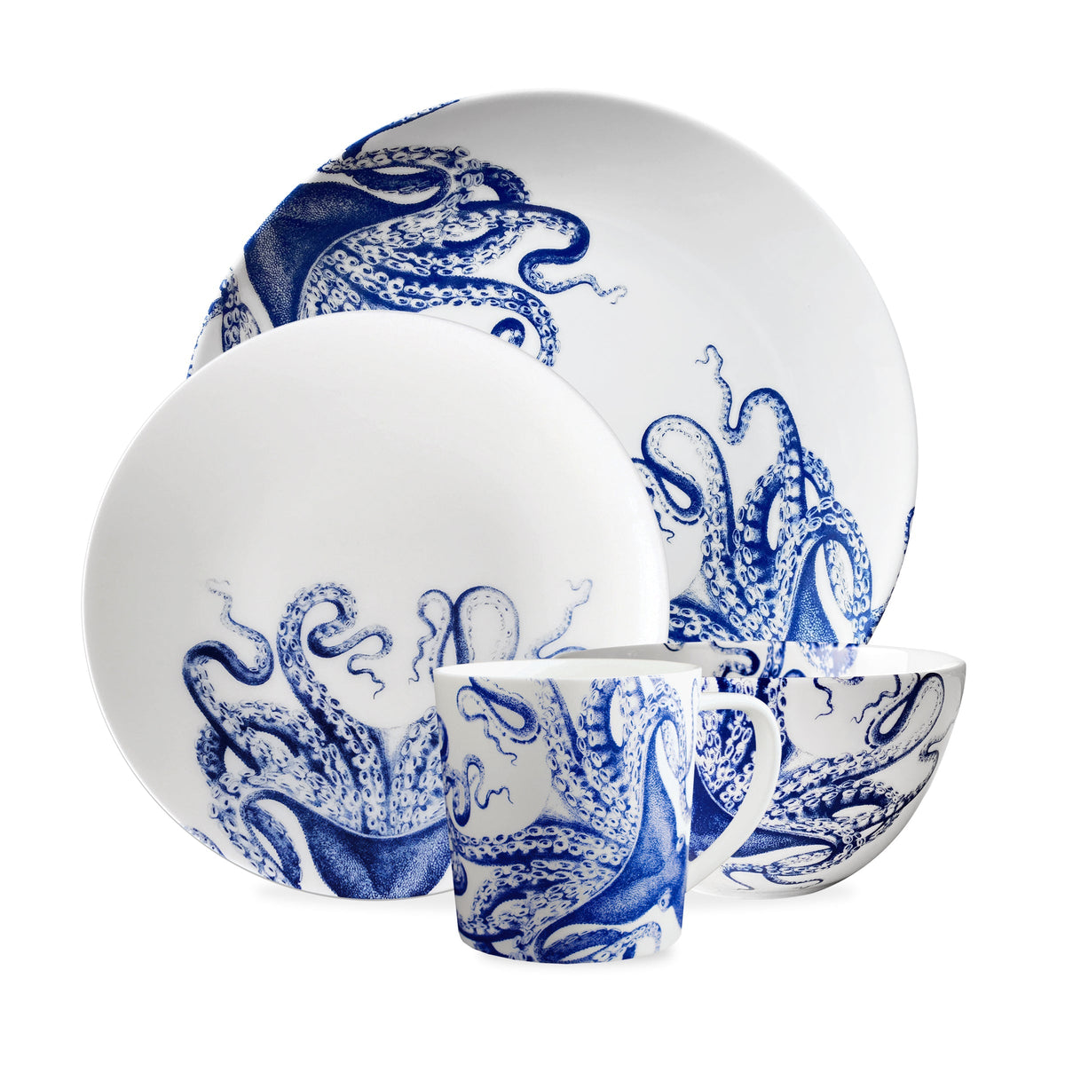 A Lucy Coupe Dinner Plate by Caskata Artisanal Home featuring blue Lucy the octopus designs, including two coupe dinner plates, a bowl, and a cup.