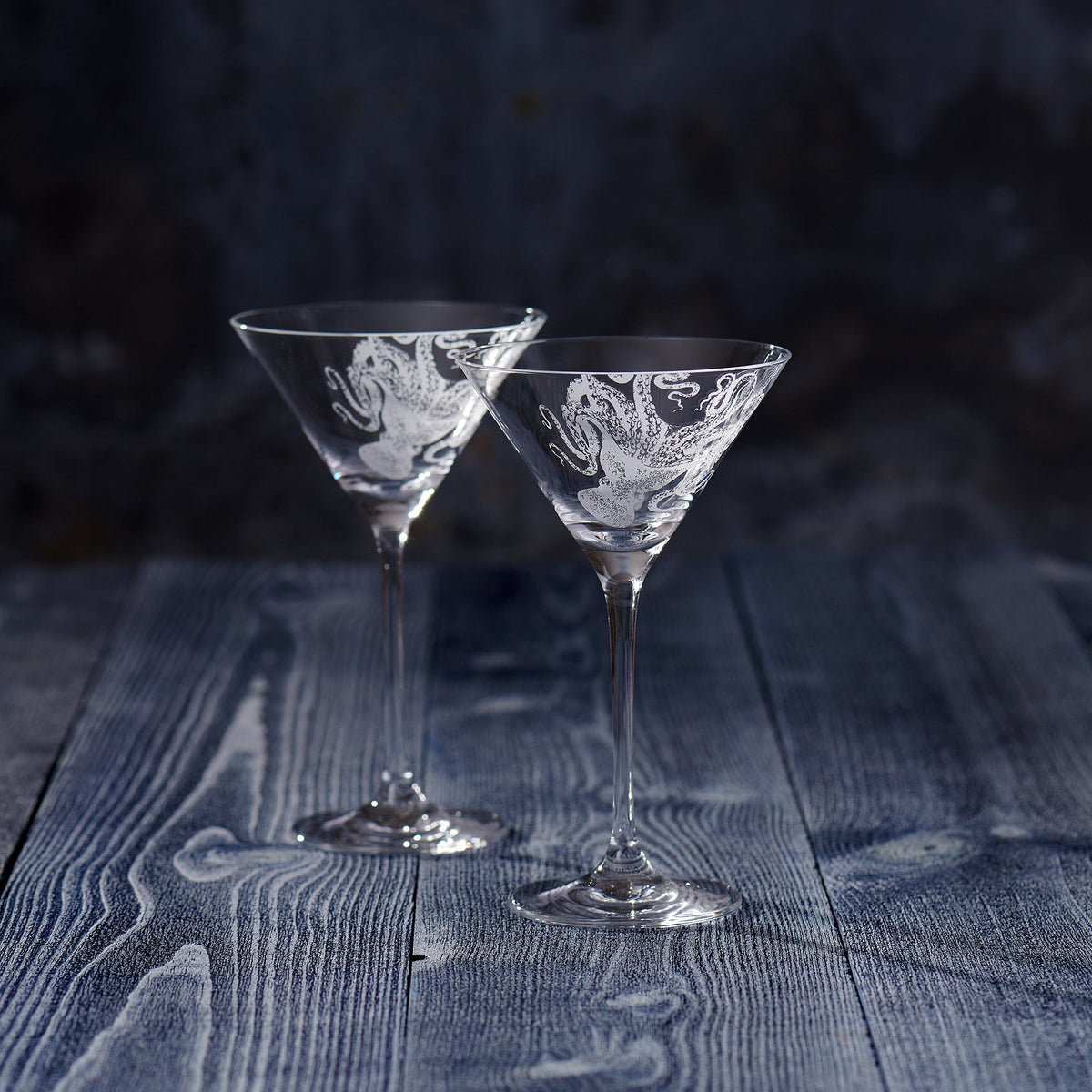 Two Lucy Martini Glasses by Caskata Artisanal Home on a wooden table.