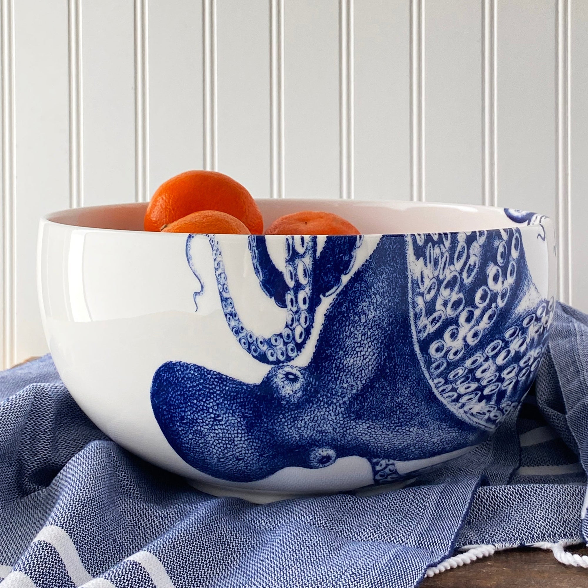 A blue and white porcelain Lucy Large Round Serving Bowl with an octopus signature motif from Caskata Artisanal Home.