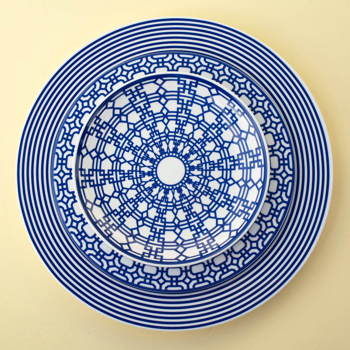 A blue and white Caskata Artisanal Home Newport Garden Gate Salad Plate with a design on it.