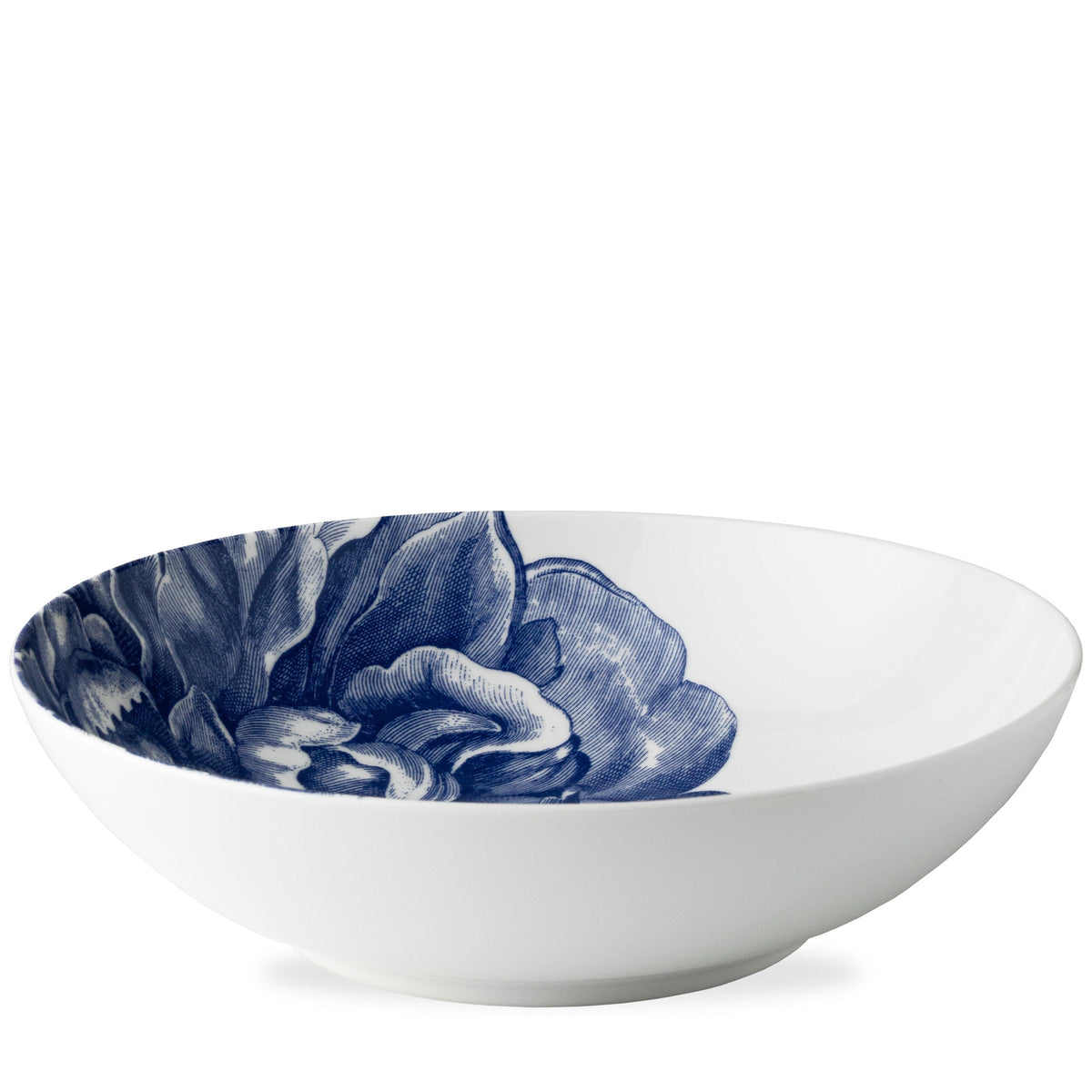 A Peony Wide Serving Bowl from Caskata Artisanal Home, with a blue floral pattern inside.
