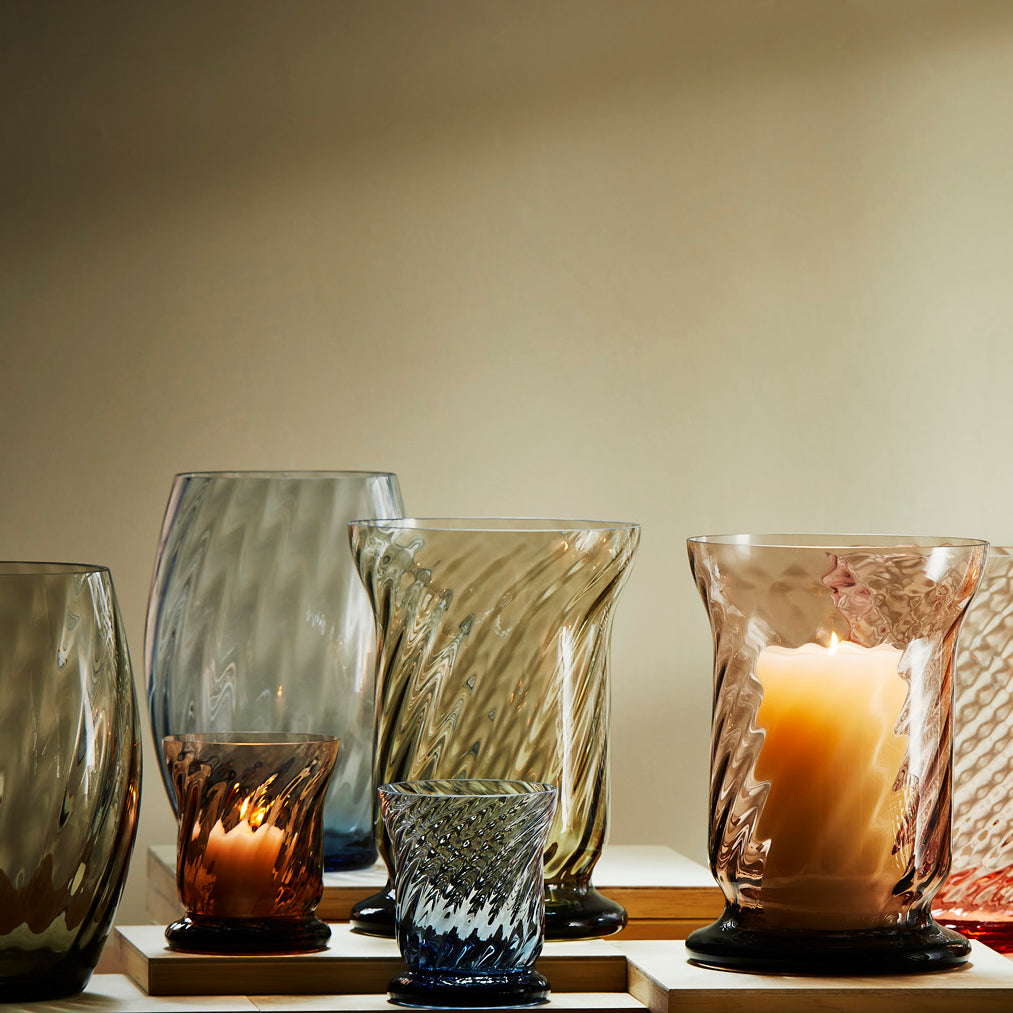 Quinn optic votives and hurricanes in mixed colors of ocean, smoke, amethyst and amber.