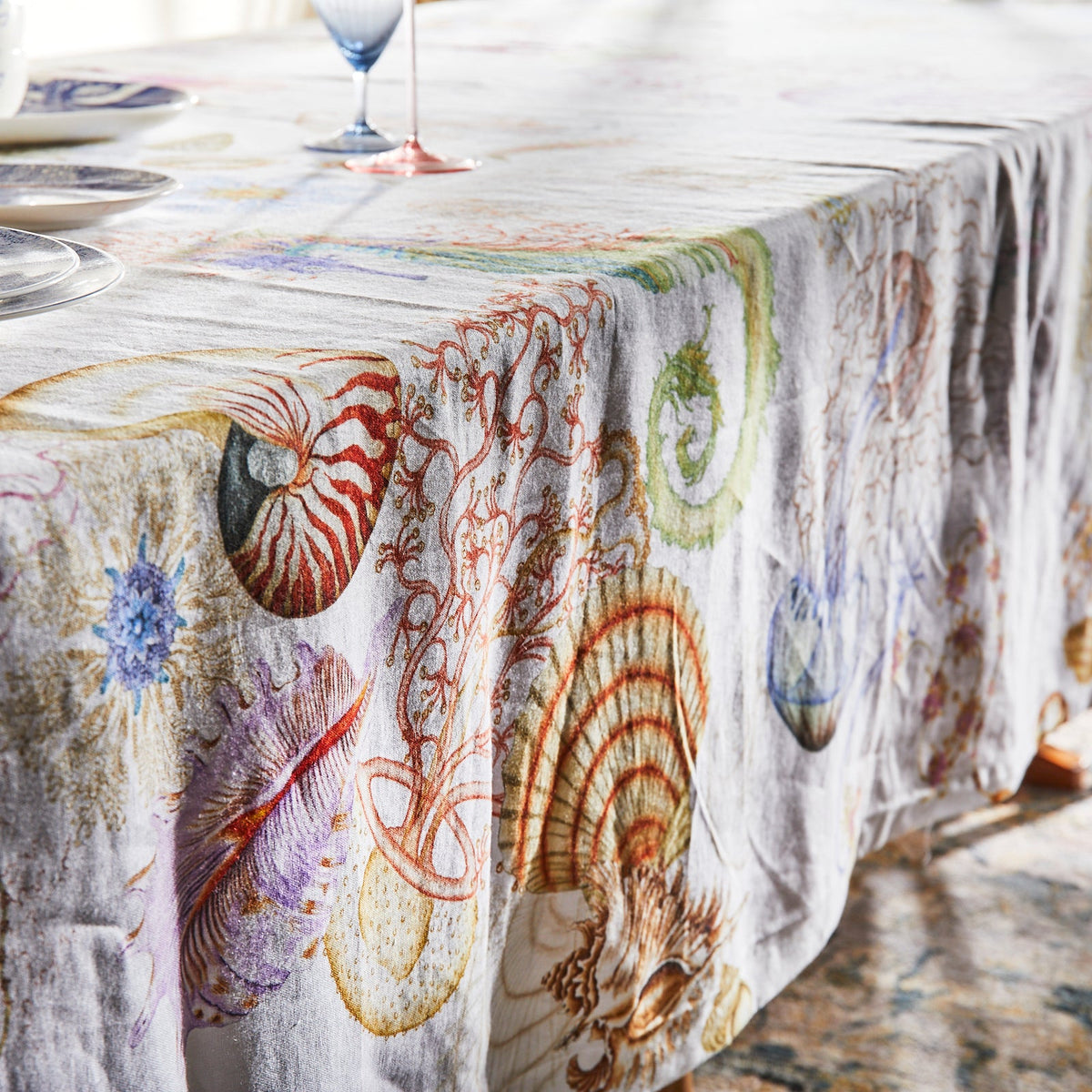 A Sanibel Linen Tablecloth with sea shells on it, perfect for shell collecting enthusiasts.