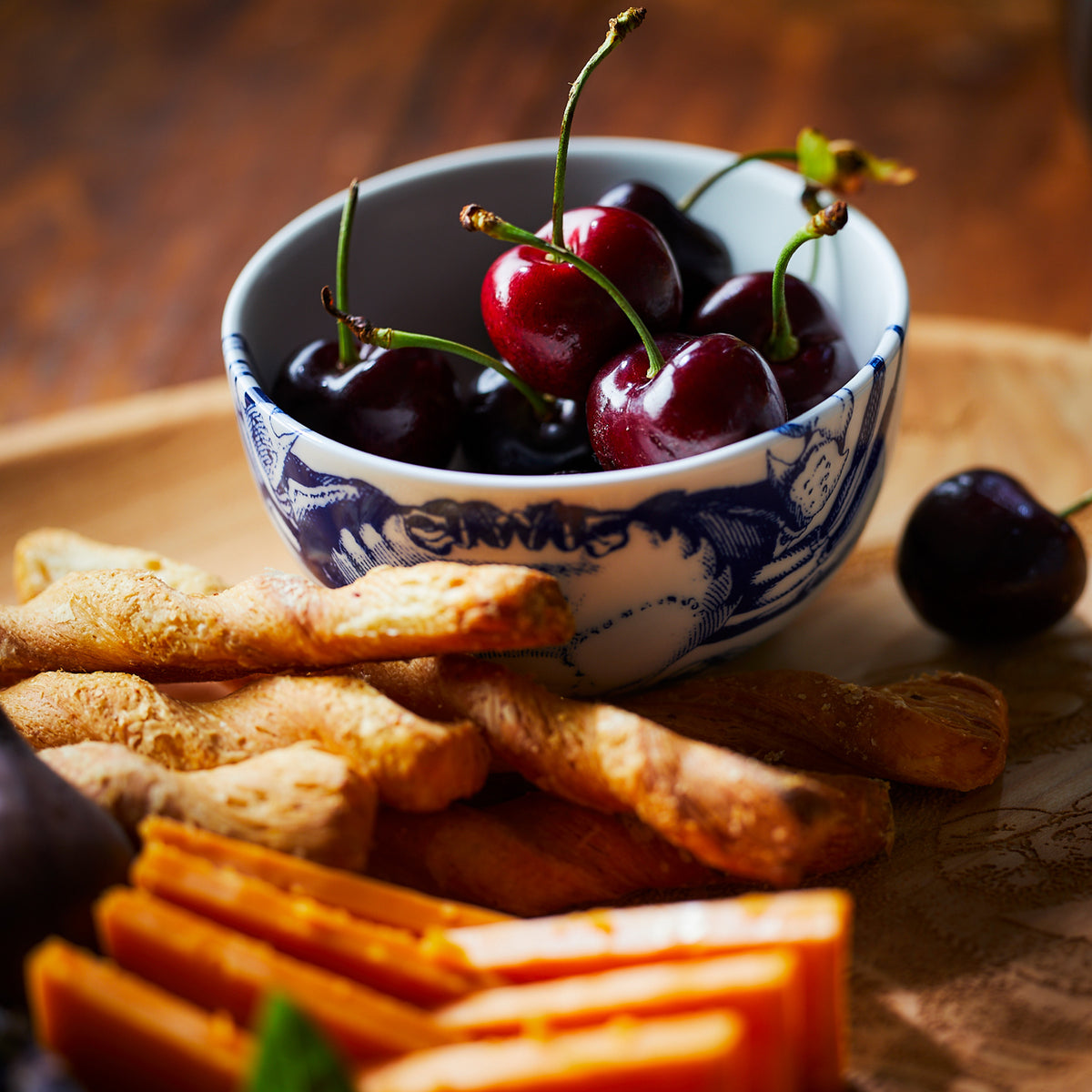 A Crab Snack Bowl of cherries and carrot sticks on a table by Caskata Artisanal Home.
