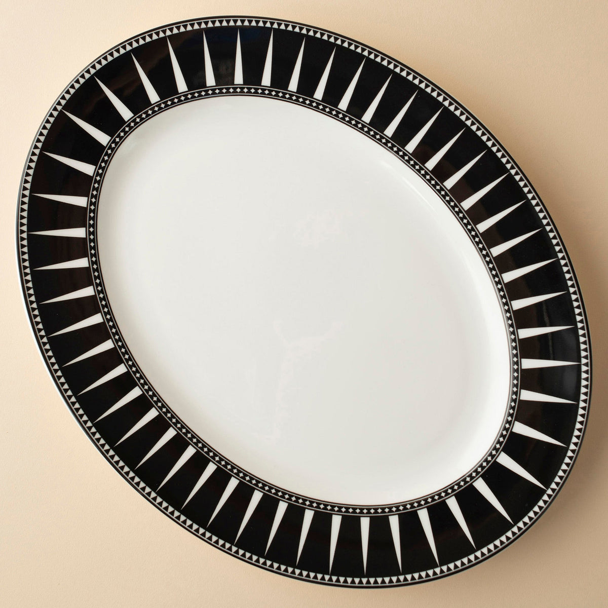 Marrakech Oval Rimmed Platter with a white center and black rim featuring white triangular patterns, reminiscent of Moroccan-inspired ceramics, by Caskata Artisanal Home.