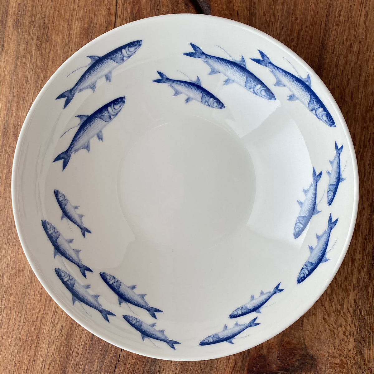 A School of Fish Wide Serving Bowl with fish, serving as a beautiful centerpiece, made by Caskata Artisanal Home.