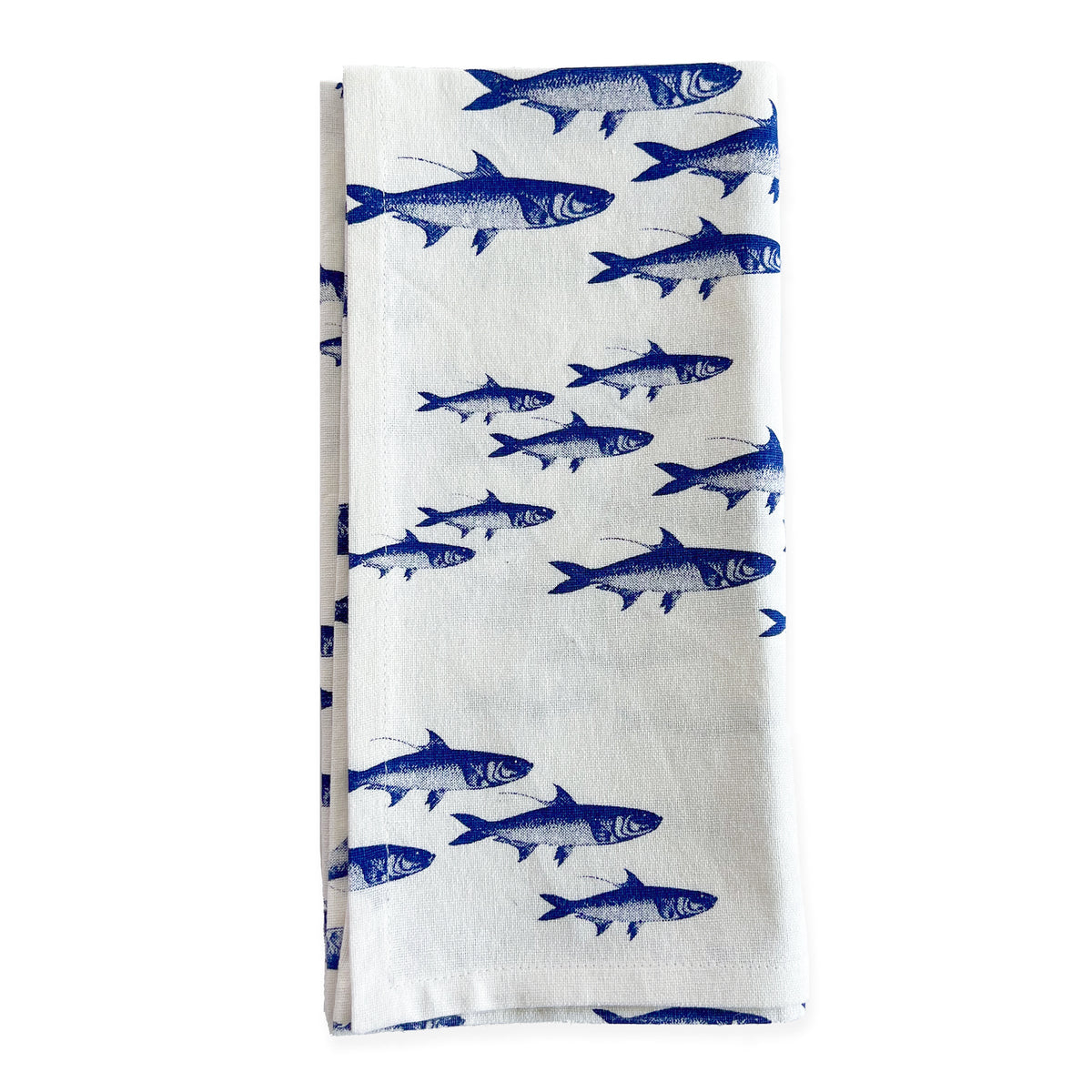 A set of School of Fish Dinner Napkins from Caskata, made of 100% cotton and featuring a pattern of blue fish printed in rows against a white background, isolated on a white surface.