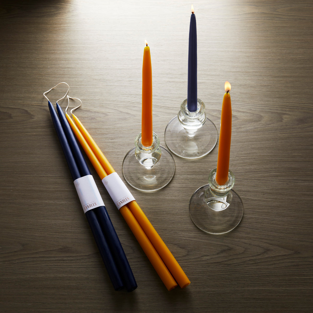 Three 12&quot; Ochre Taper Candles - Set of 2 by Floral Society are sitting on a table.