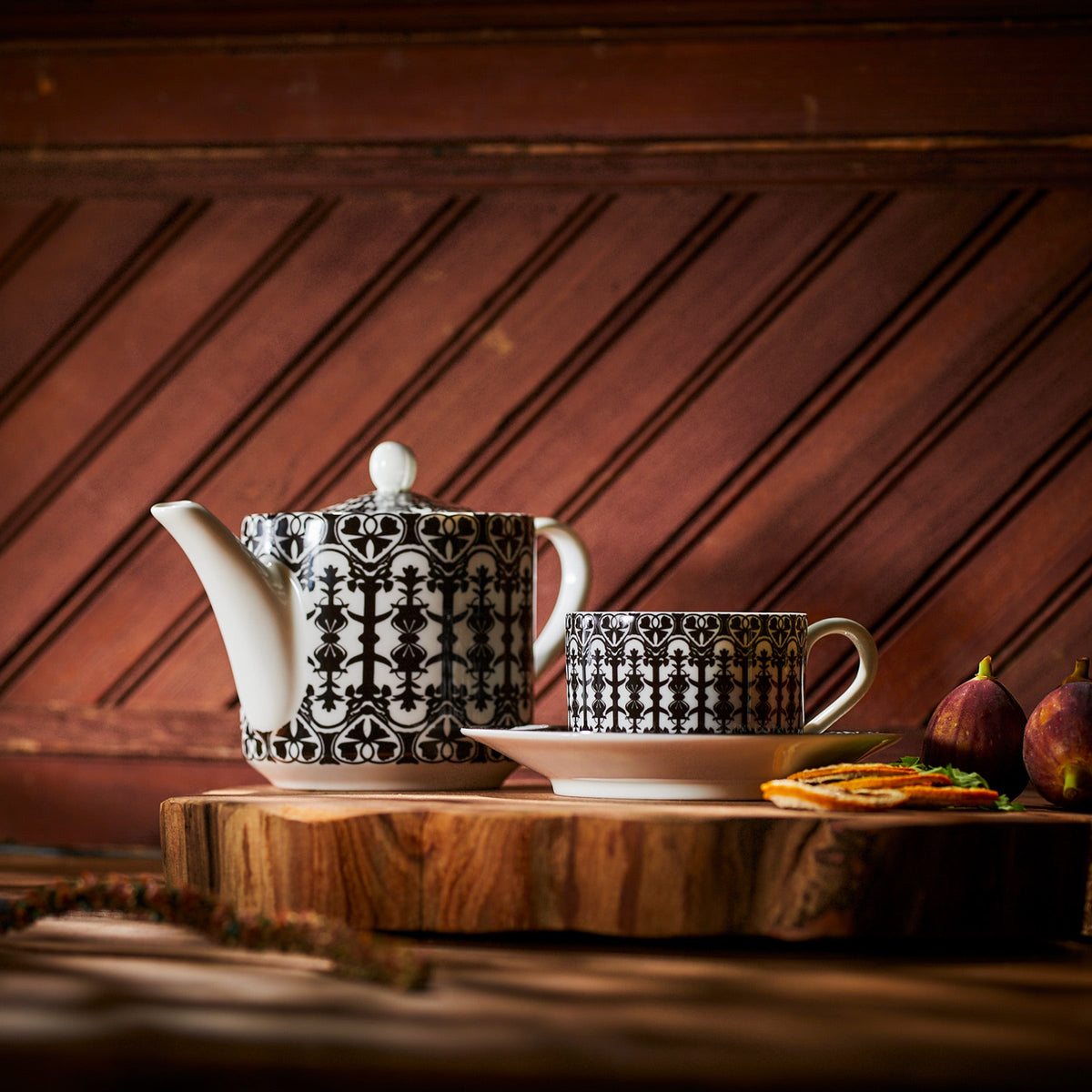 A Casablanca Petite Teapot from Caskata and a cup on a wooden cutting board.