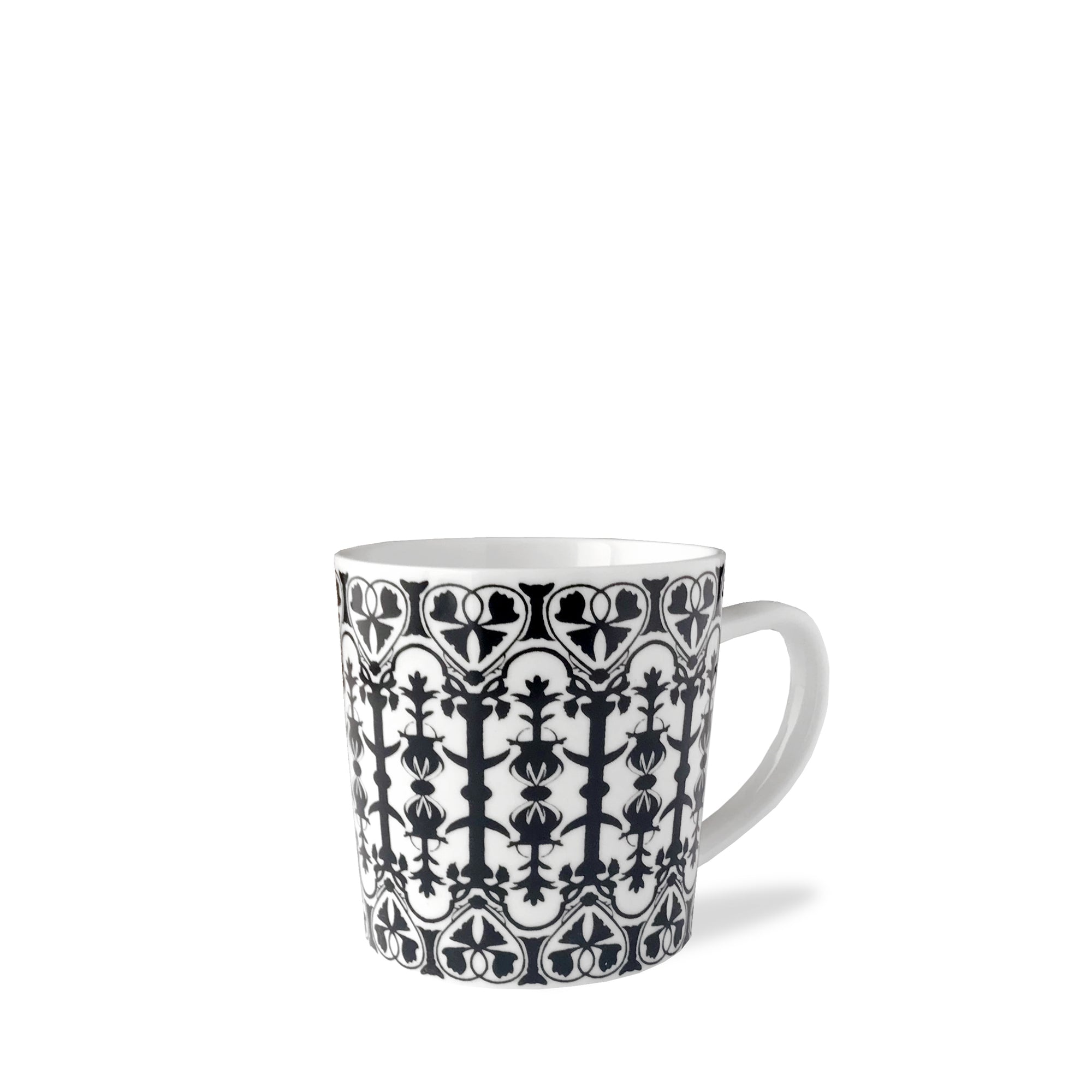 A white ceramic mug with a black intricate pattern featuring symmetrical shapes and lines. The Casablanca Mug, by Caskata Artisanal Home, has a handle on the right side.