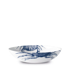A white ceramic bowl with a blue crab pattern on both the interior and exterior, crafted from high-fired porcelain for added durability. This elegant piece, the Crab Entrée Bowl by Caskata Artisanal Home, is also dishwasher and microwave safe, making it both beautiful and practical for everyday use.