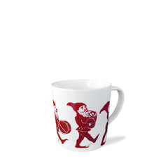 White porcelain Elves Mug with red illustrations of playful elves marching, one playing a drum and another carrying a basket. Perfect for the Caskata Artisanal Home holiday collection.