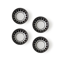 Four black and white plates, designed in a Moroccan-inspired pattern, are arranged in a grid on a plain white background. Each plate features circular designs with radial stripes. These are the Marrakech Dipping Dishes, Set of 4 by Caskata.