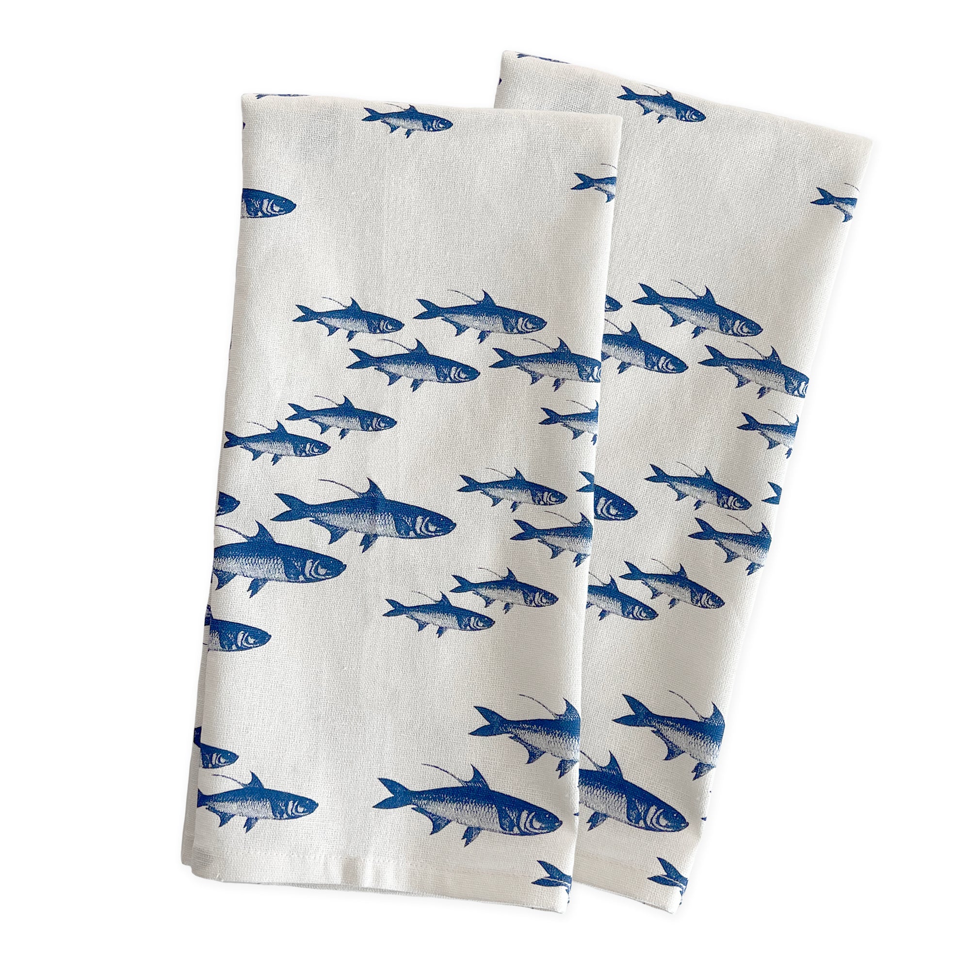 Two folded Caskata School of Fish Kitchen Towels, Set of 2, arranged diagonally on a plain background.