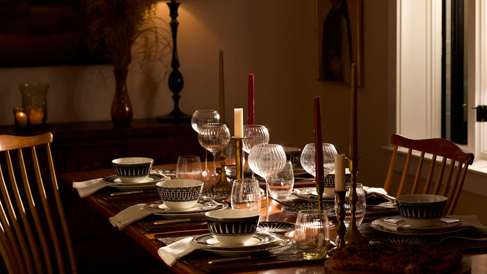 A table set with black and white porcelain and crystal wine glasses, gleaming in the late afternoon sun.