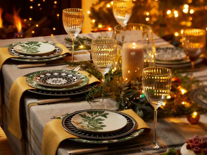 Holiday table setting with Caskata Arbor Green and Casablanca patterned dinner plates paired with Quinn crystal wine glasses