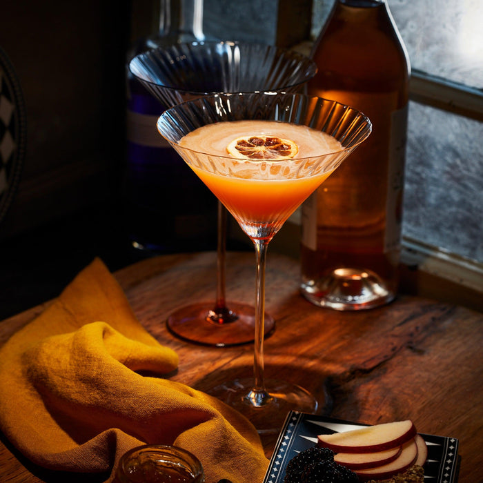 A fall apple and pear martini cocktail in a Quinn Amber Martini glass.