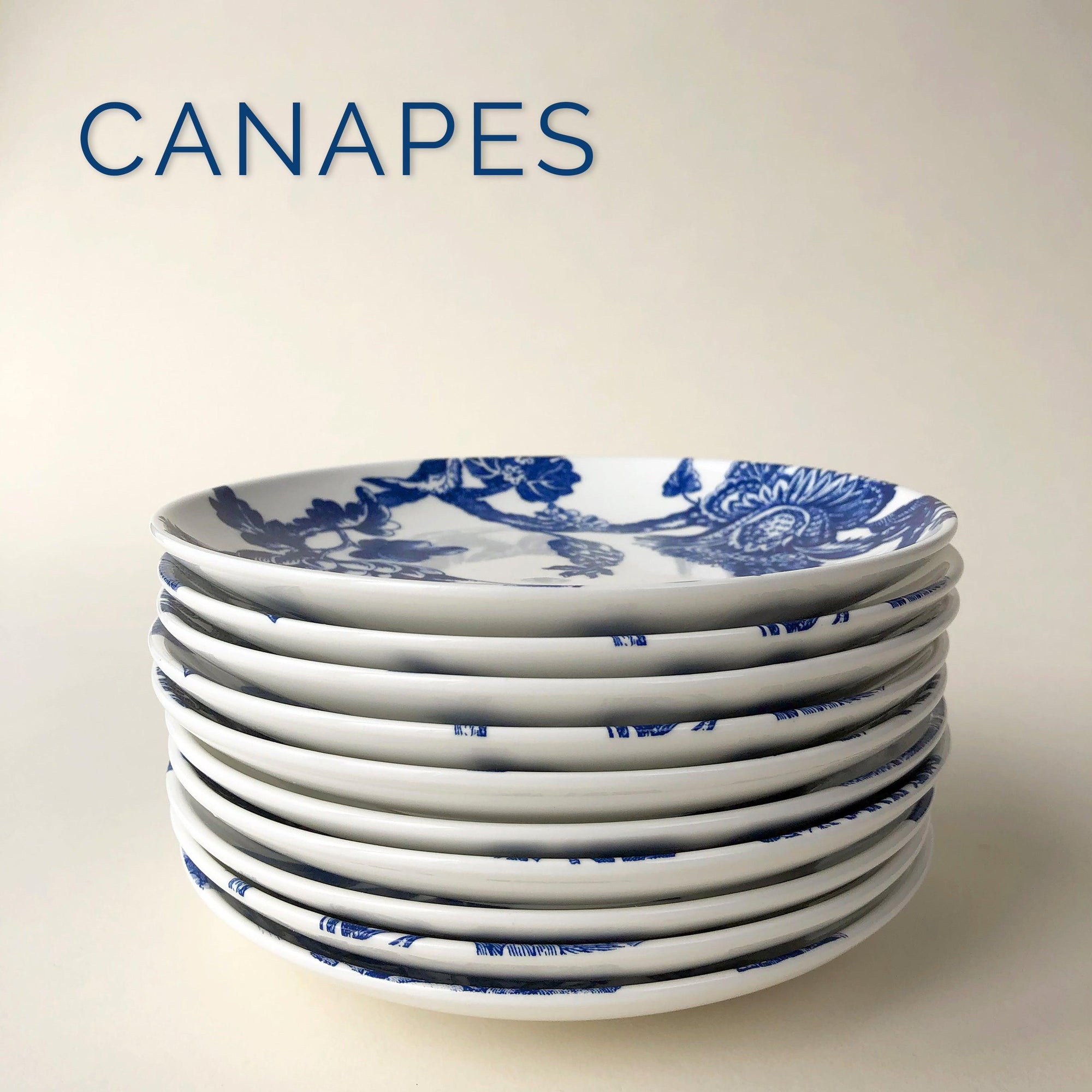 A stack of blue and white plates with the words canapés.