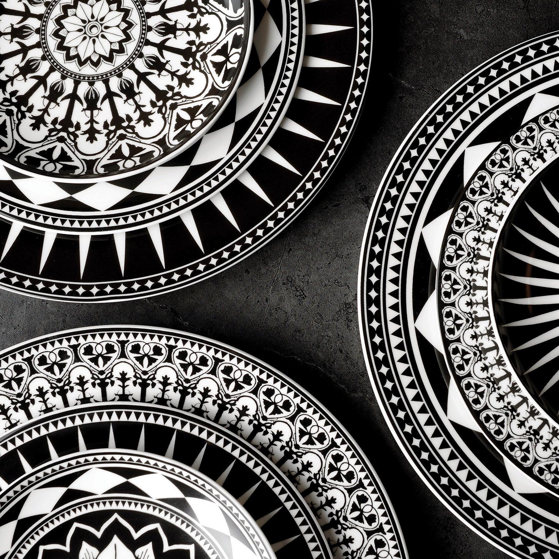 Close-up of intricate black and white patterned plates on a dark textured surface.