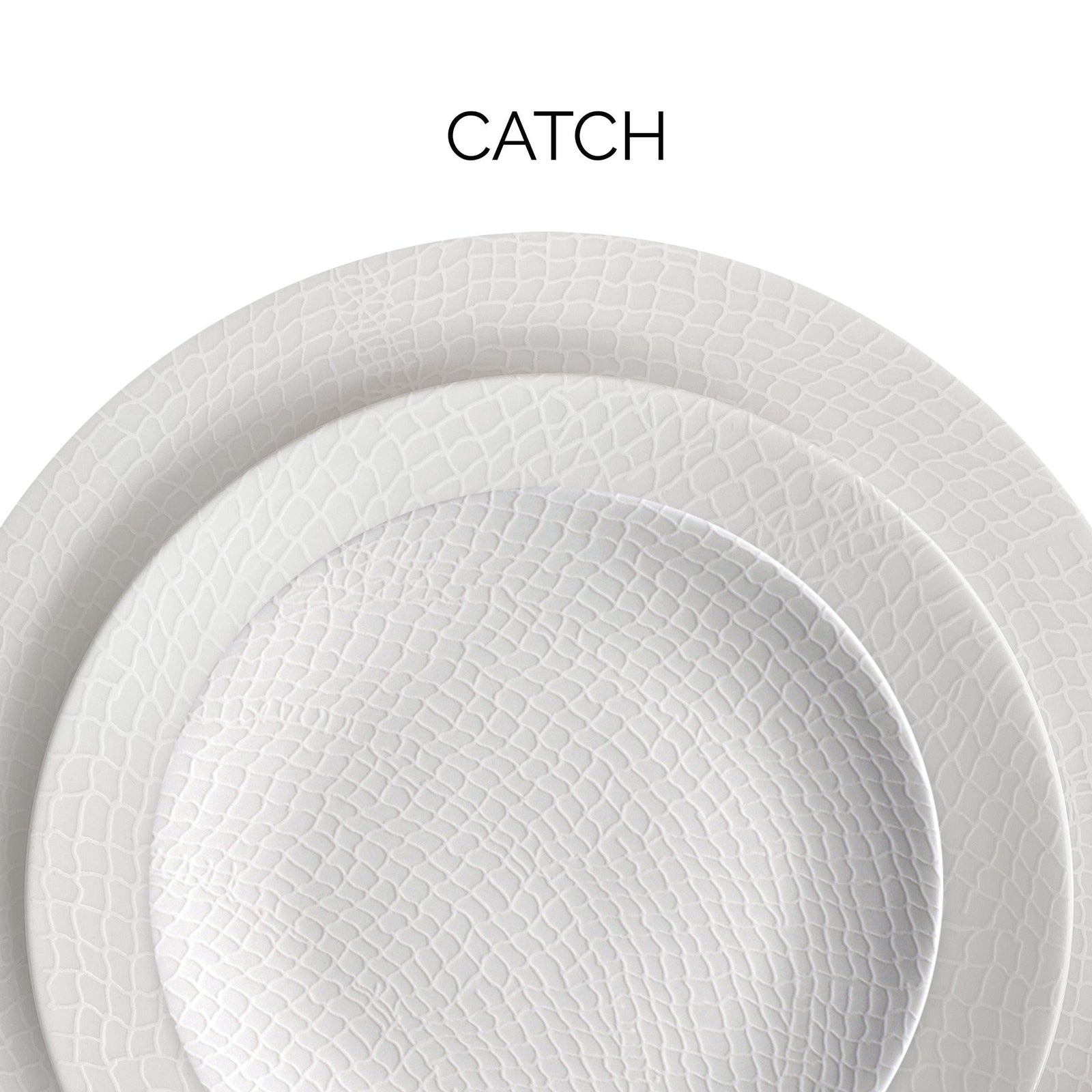 Close-up of two stacked textured white plates with the word "CATCH" above them.