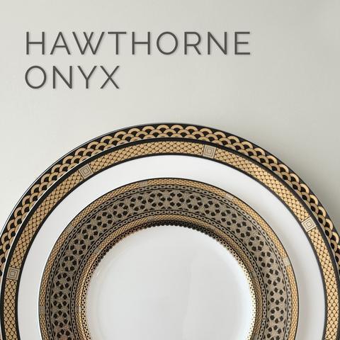 A white plate with intricate gold and black geometric patterns, labeled "Hawthorne Onyx.