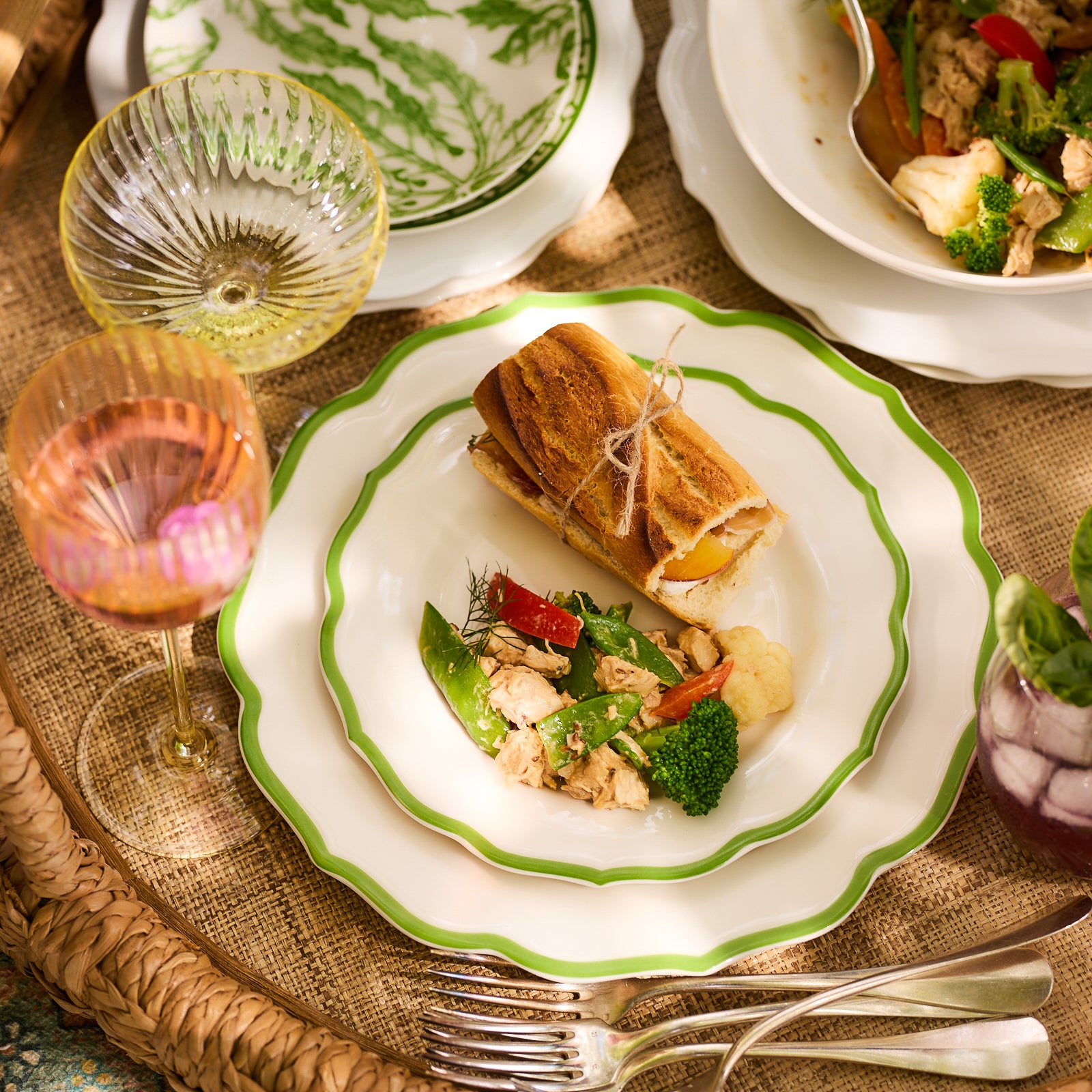 The Stella Scalloped Verde Dinner Plate by Caskata features a white design with a green border, embodying the timeless charm of vintage dinnerware.