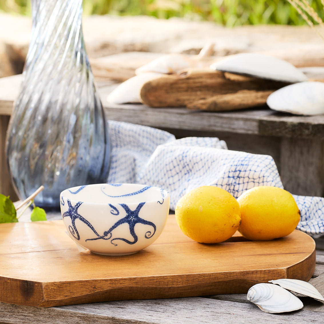 The Caskata Artisanal Home Starfish Snack Bowl, a small porcelain piece, is beautifully adorned with blue octopus designs that elegantly intertwine with intricate starfish motifs.