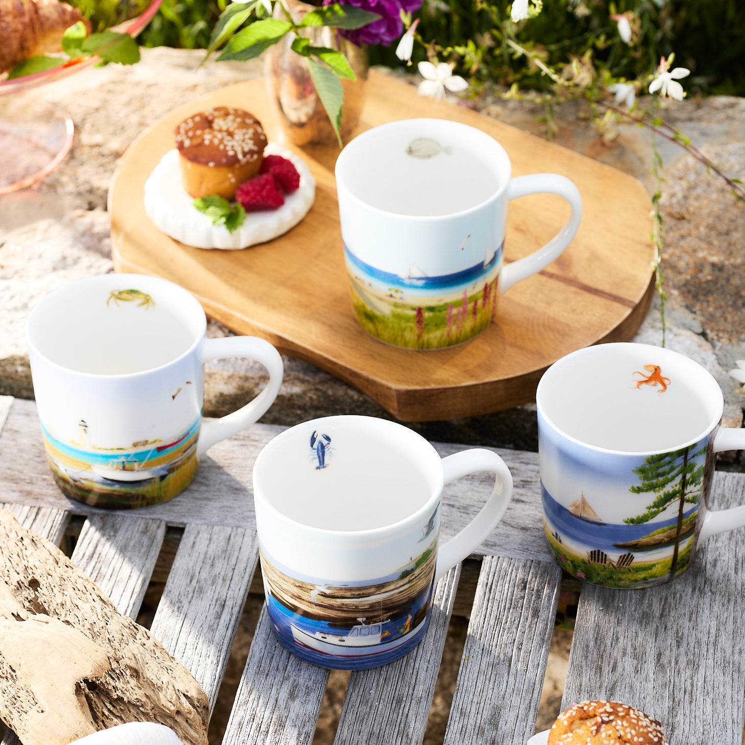 The Caskata X Felix Doolittle By the Sea Mugs, Set of 4, features ceramic mugs adorned with beautiful coastal scenes inspired by Felix Doolittle's watercolor landscapes. Each mug showcases illustrations of boats, lighthouses, seagulls, and scenic landscapes with trees and flowers.