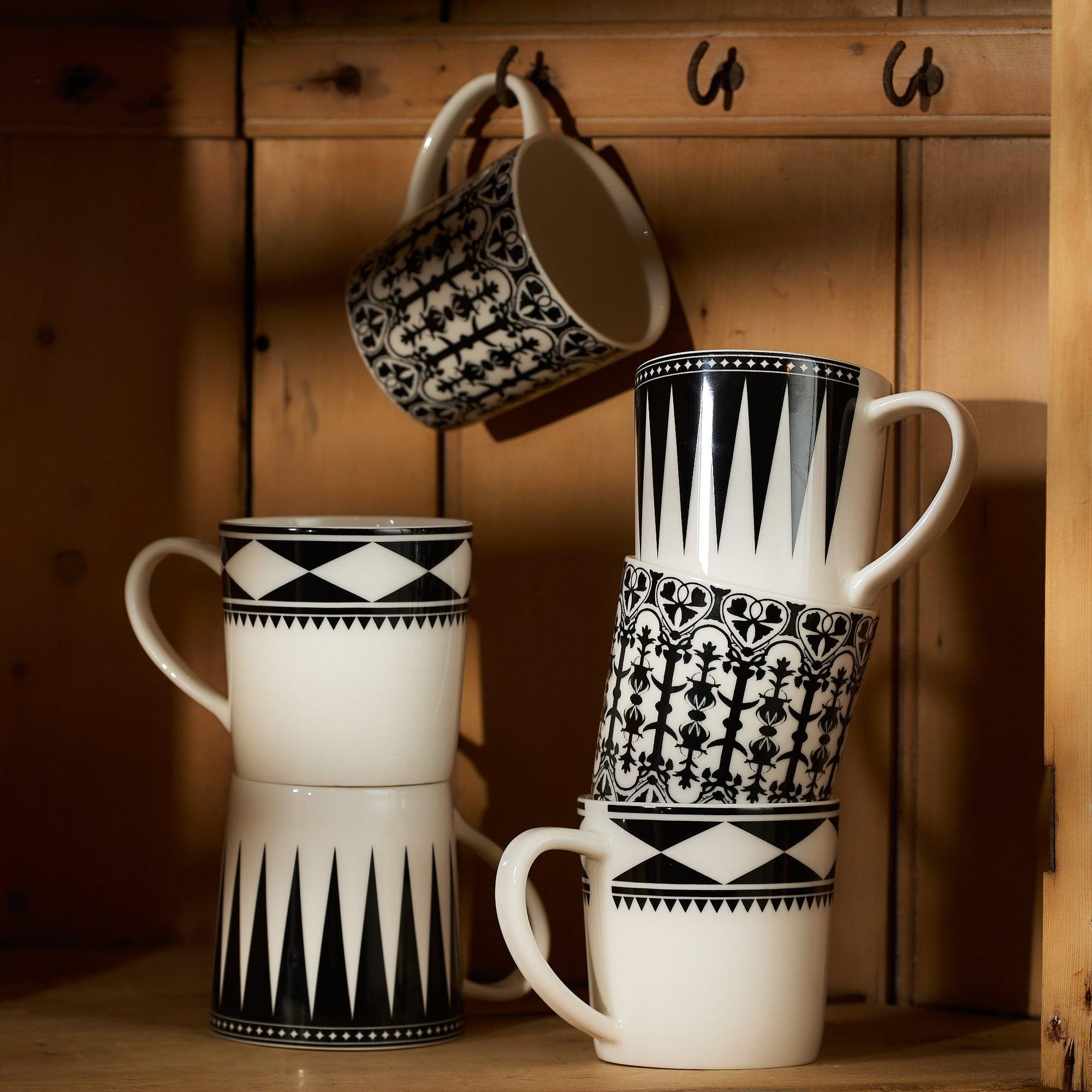 Fez Mug by Caskata Artisanal Home made of high-fired porcelain with black geometric patterns including diamonds and triangles near the rim. Dishwasher and microwave safe.