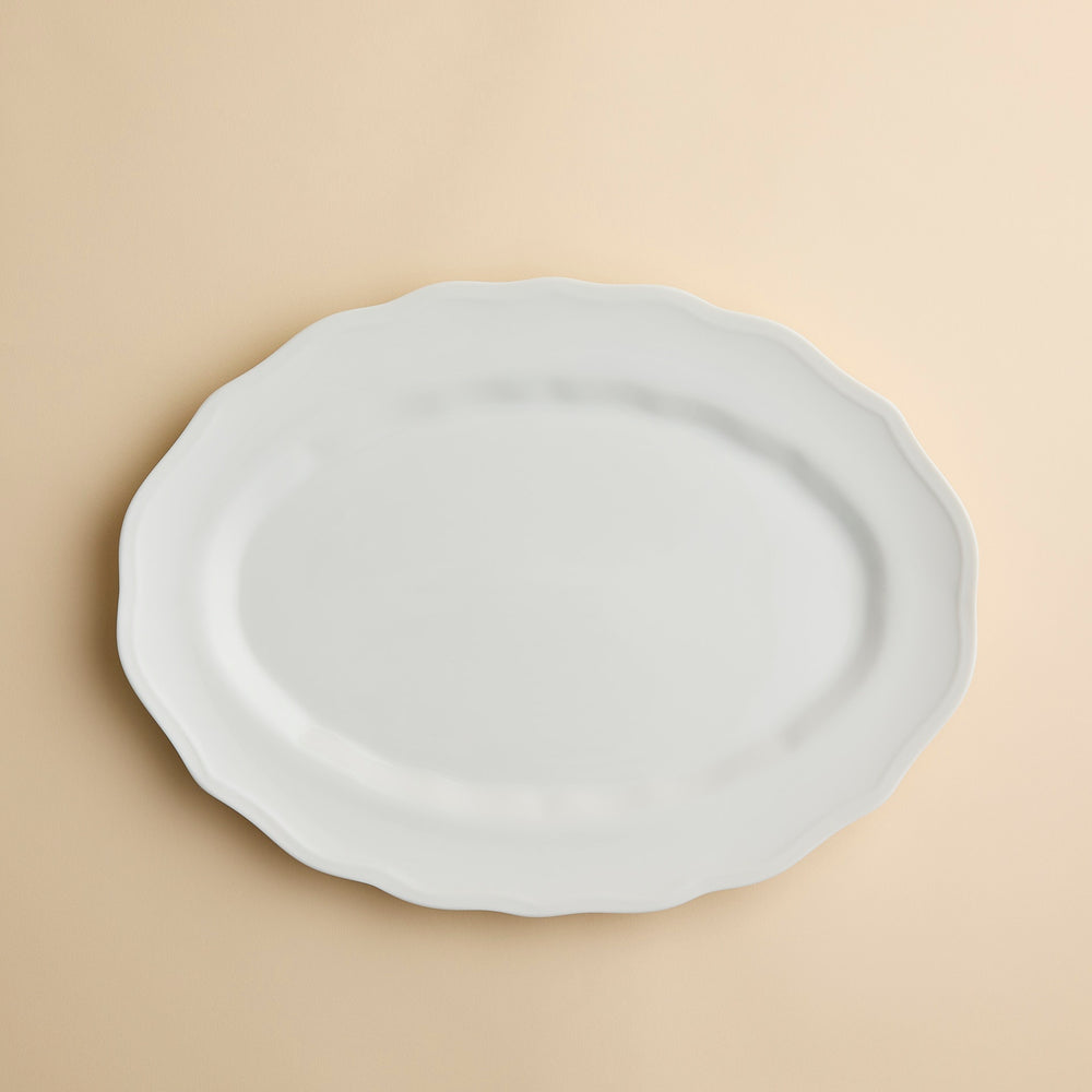 Caskata Stella White Scalloped Platter, a white oval serving dish in high-fired porcelain with a scalloped edge.
