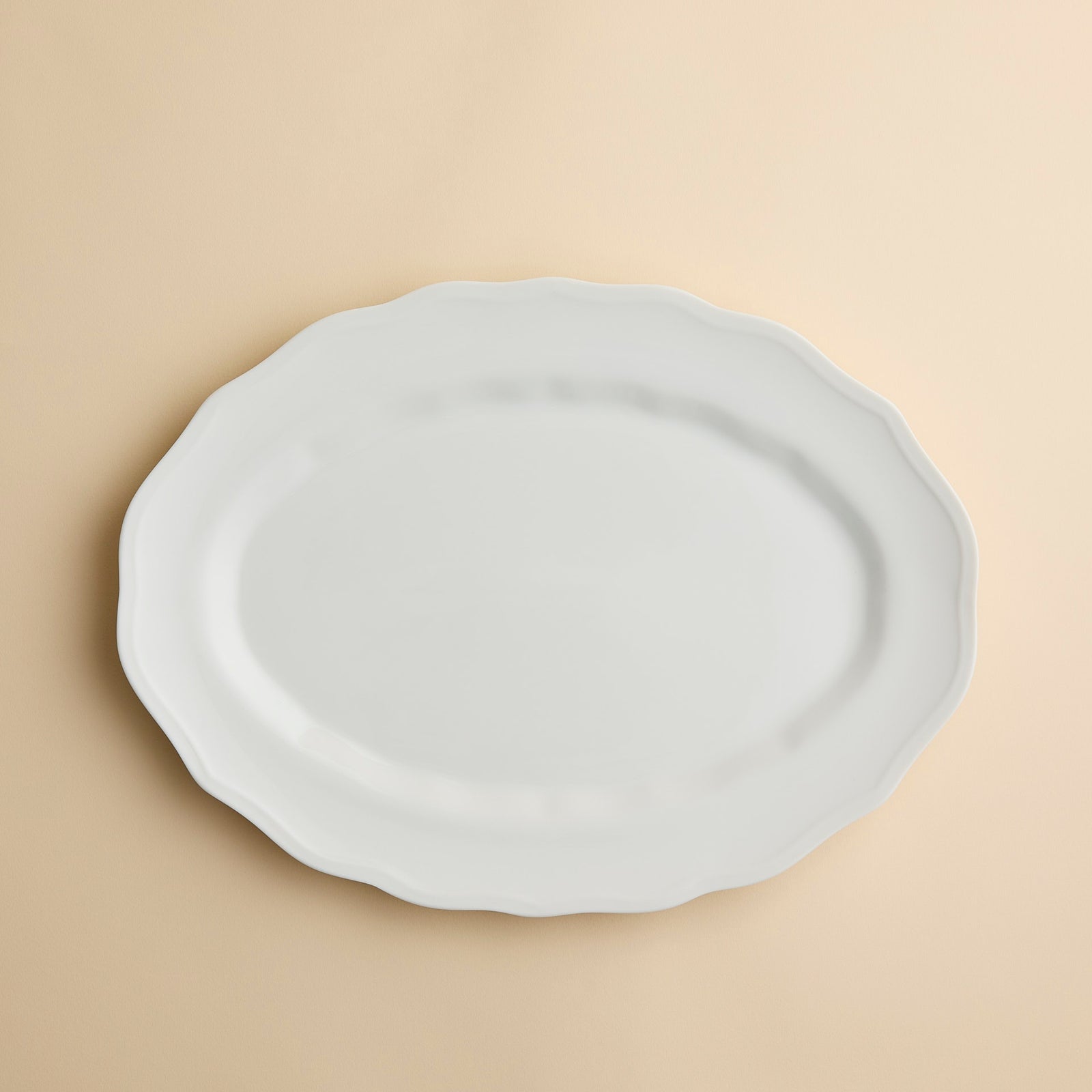 Caskata Stella White Scalloped Platter, a white oval serving dish in high-fired porcelain with a scalloped edge.