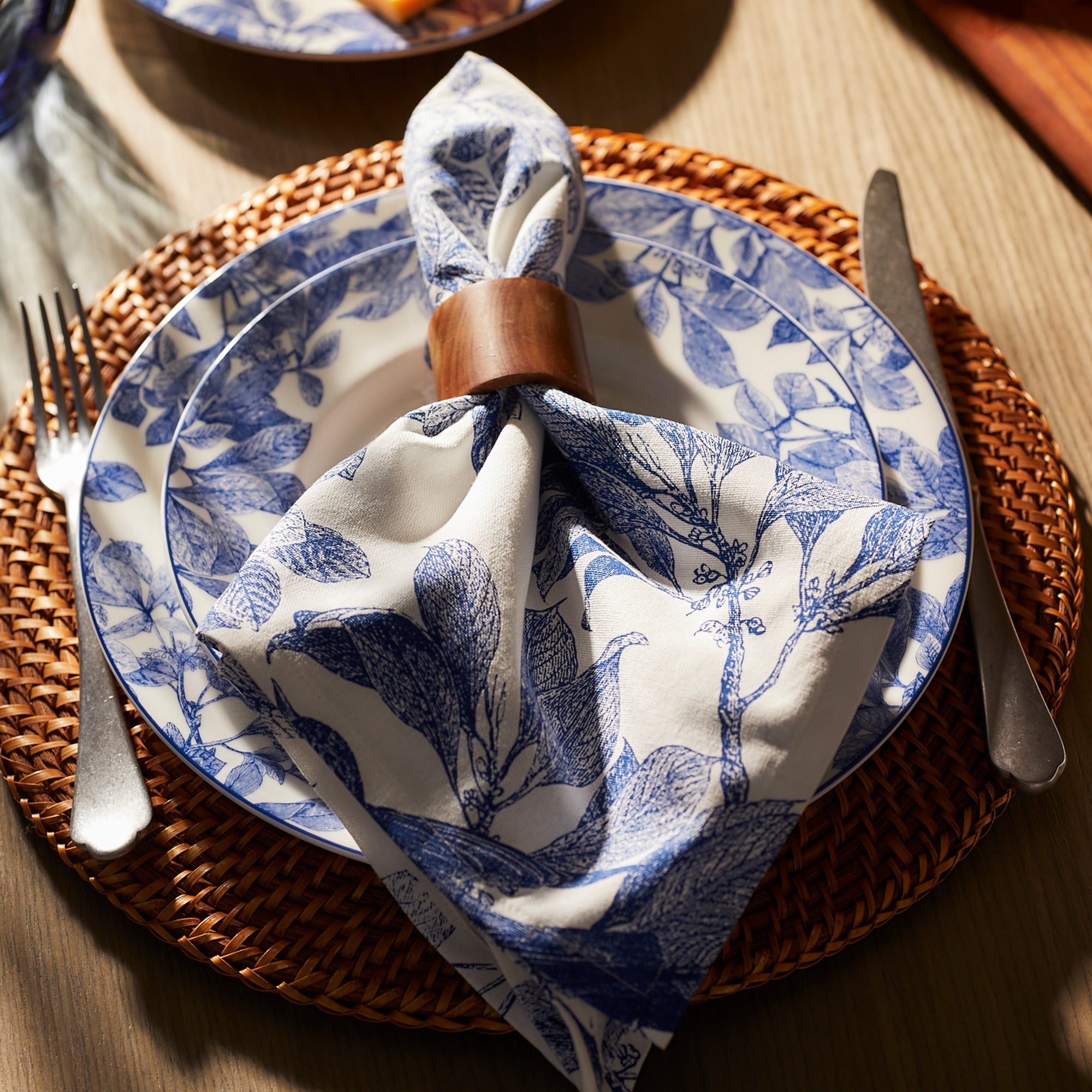 A blue and white table setting with a Dot and Army Round Wooden Napkin Rings Set/4 and fork.