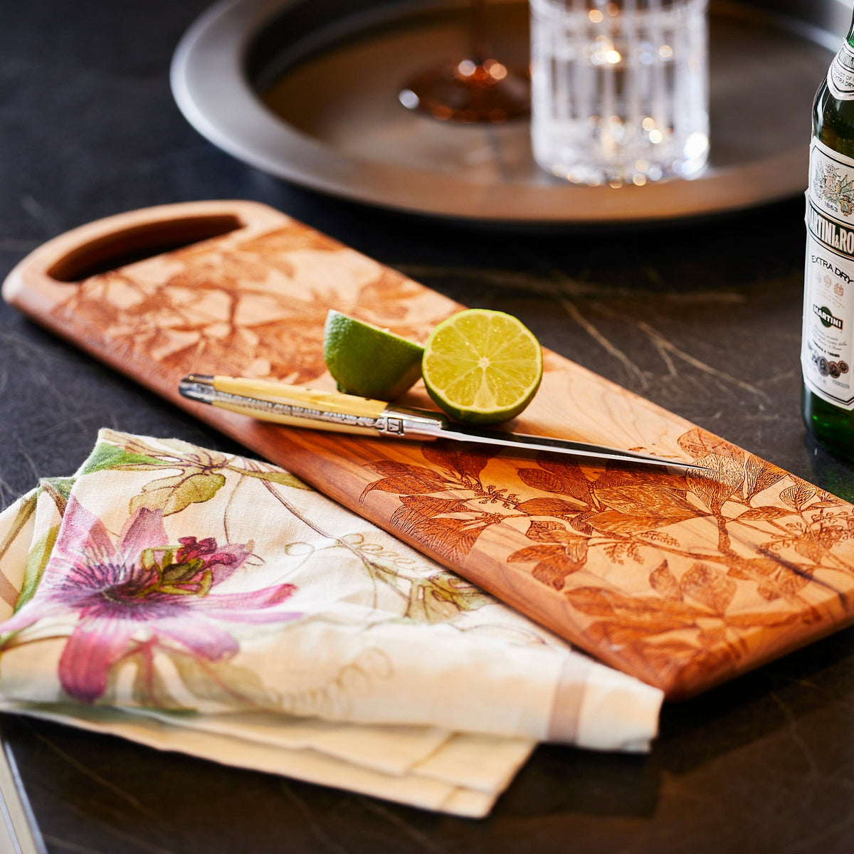 A Passionflower Linen Kitchen Towels Set/2, manufactured by TTT, decorated with a lime and accompanied by a bottle of wine.