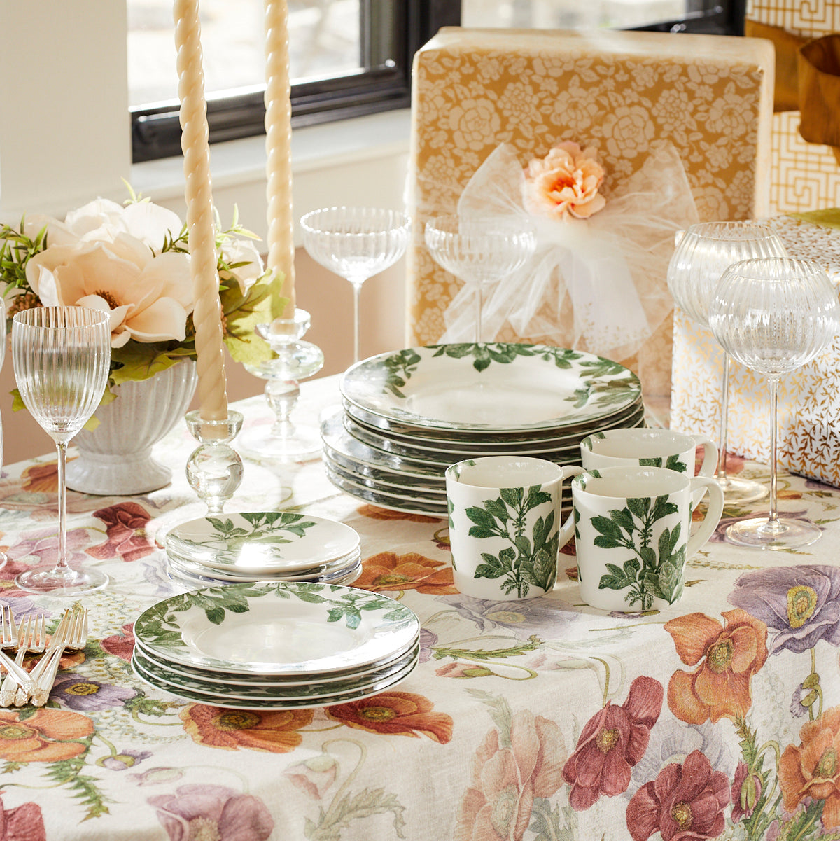 A natural floral tablecloth on a table with Floral Society&#39;s 18&quot; Parchment White Twist Taper Candles - Set of 2.